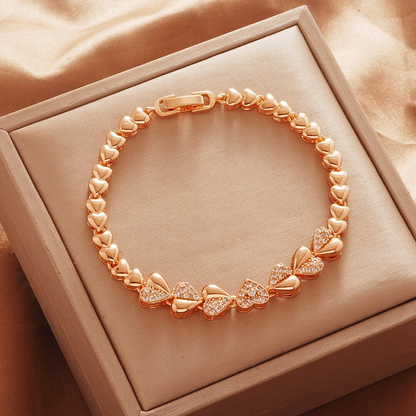 Gold Tone bracelet, style TSL012, with heart-shaped links and round center accents and a clasp.
