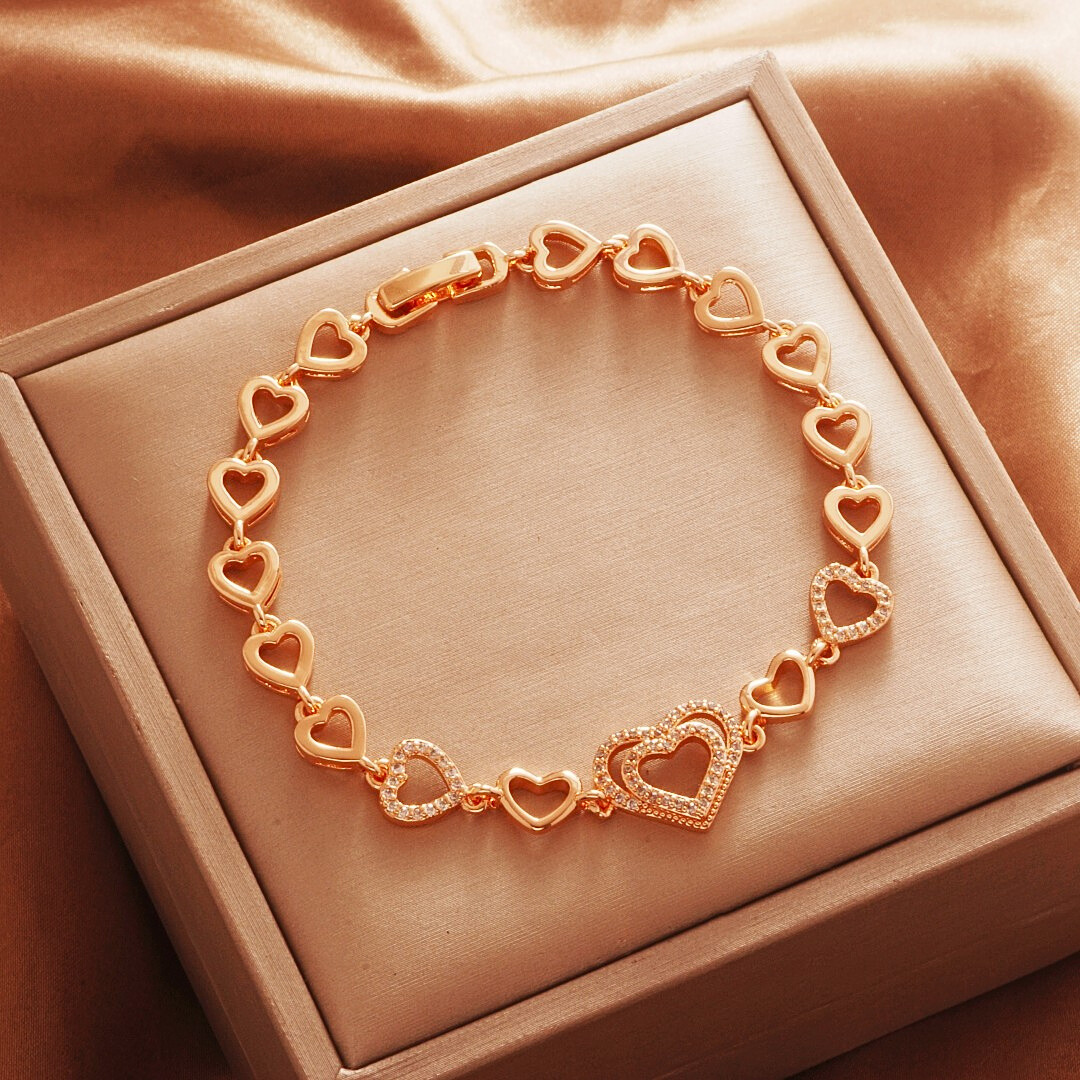 Gold Tone bracelet, style TSL015, with open-heart links and a larger stone-set heart center and a clasp.