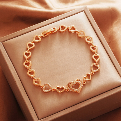 Gold Tone bracelet, style TSL015, with open-heart links and a larger stone-set heart center and a clasp.