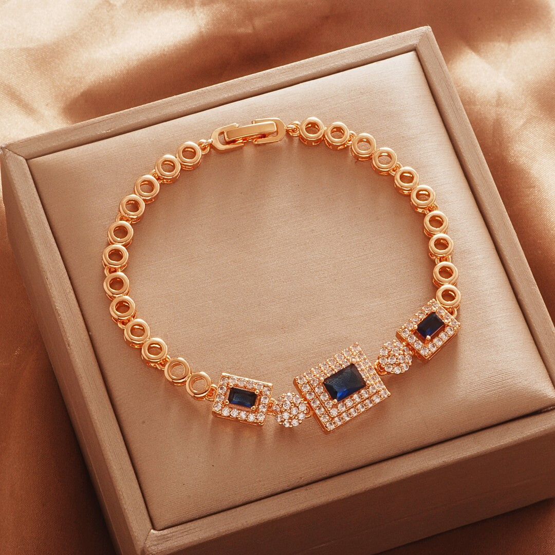 Gold Tone bracelet, style TSL018, with dark blue rectangular halo centers and round links and a clasp.