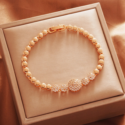 Gold Tone bracelet, style TSL019, with a round cluster center and rounded links and a clasp.