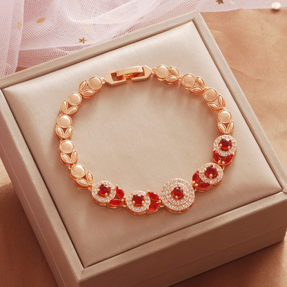Gold Tone bracelet, style TSL023, with red round halo centers and rounded links and a clasp.