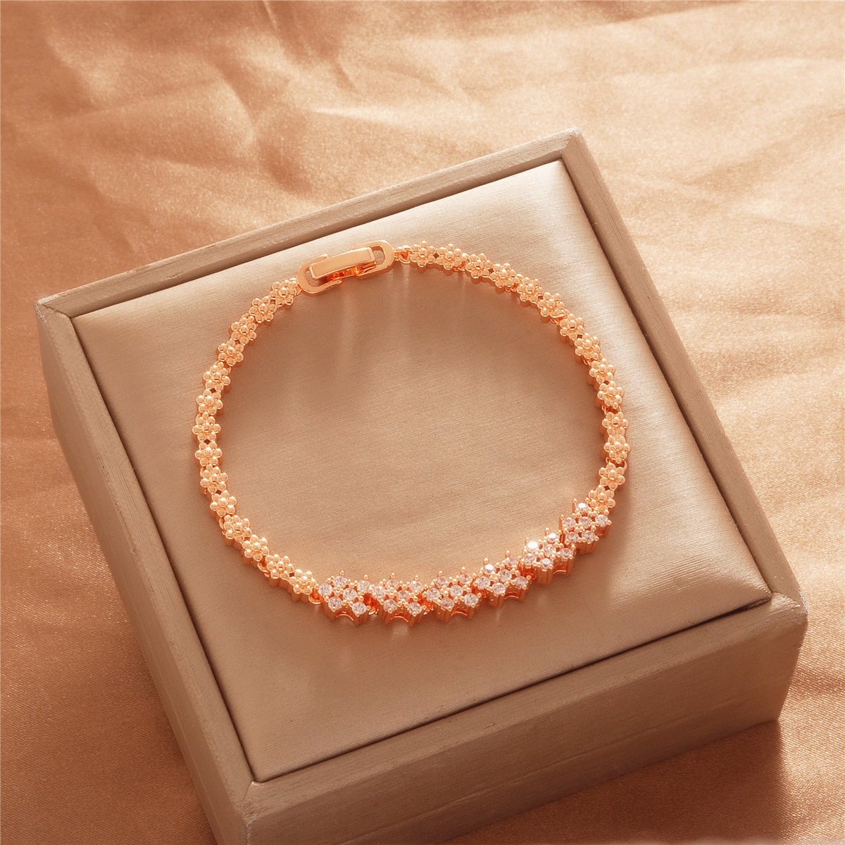 Gold Tone bracelet, style TSL026, with small repeating flower-like stone-set links and a clasp.