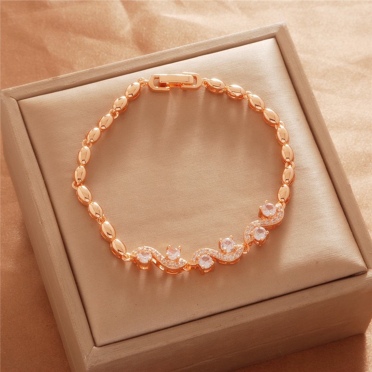 Gold Tone bracelet, style TSL029, with curved center accents with clear stones and polished oval links and a clasp.