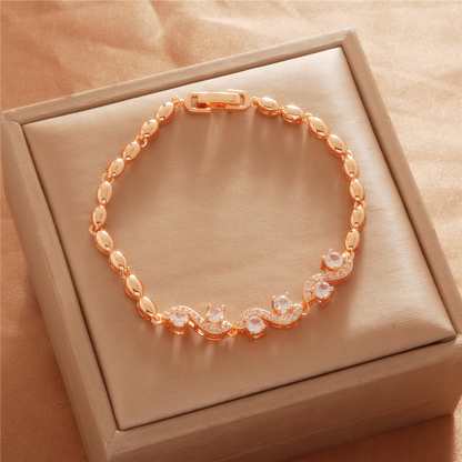 Gold Tone bracelet, style TSL029, with curved center accents with clear stones and polished oval links and a clasp.