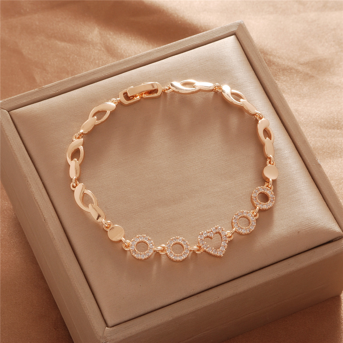 Gold Tone bracelet, style TSL032, with heart and circular center accents with open links and a clasp.