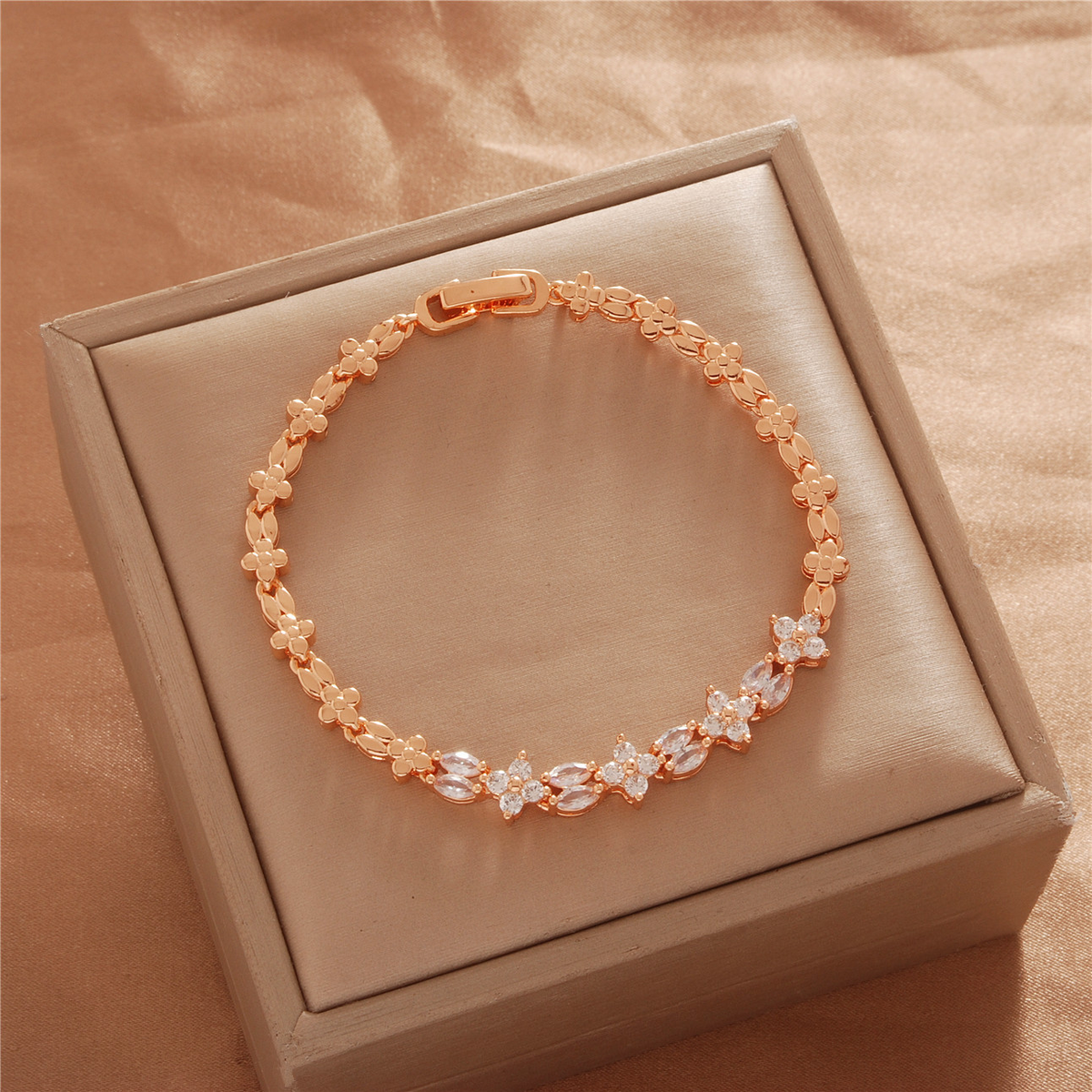 Gold Tone bracelet, style TSL033, with small flower-like accents and decorative links and a clasp.