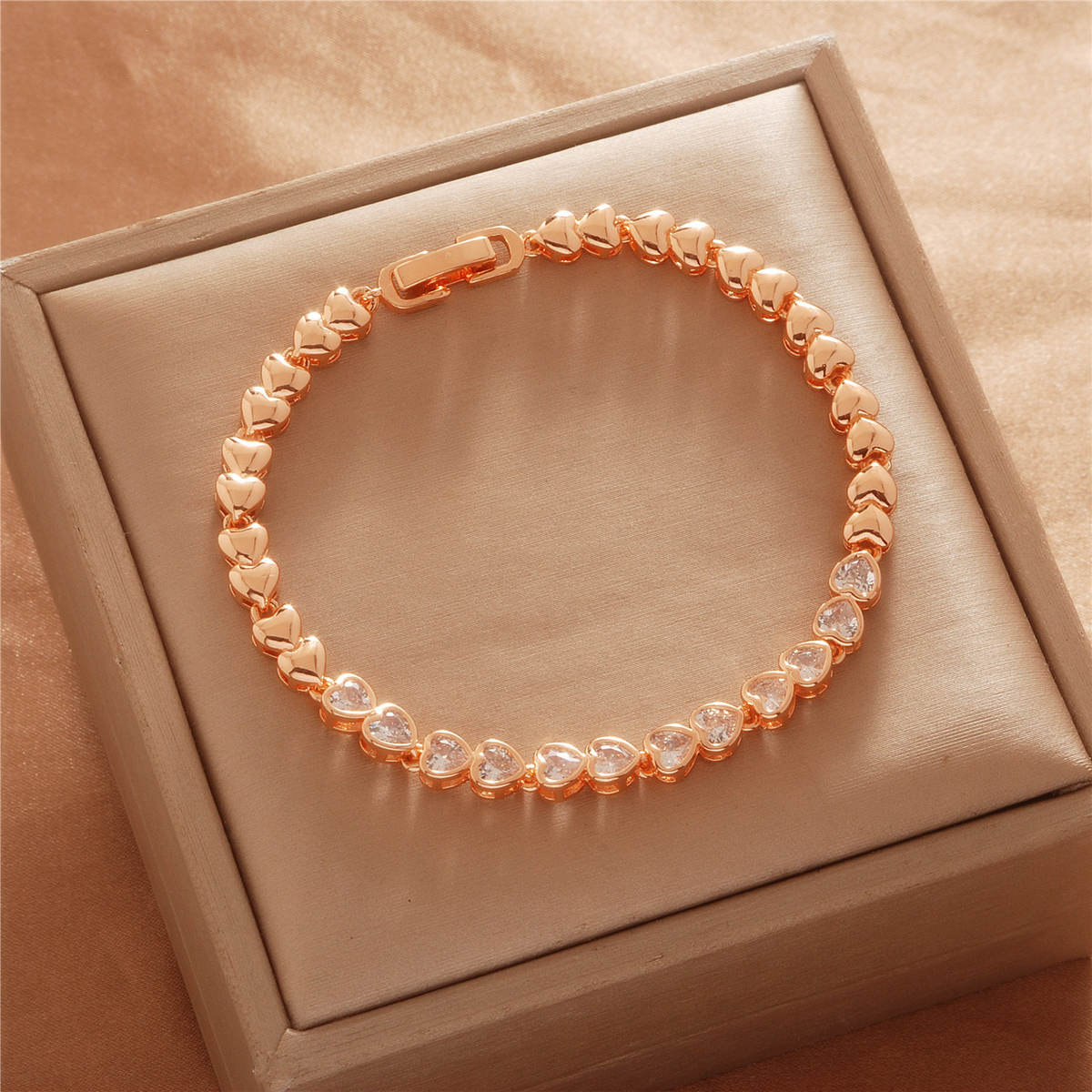 Gold Tone bracelet, style TSL034, with a row of round clear center accents and heart-shaped links and a clasp.