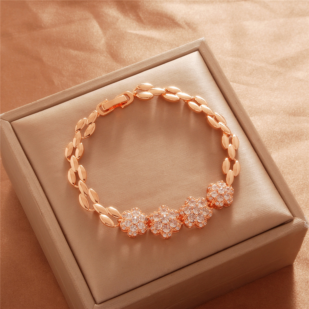 Gold Tone bracelet, style TSL035, with three flower centers and polished leaf-shaped links and a clasp.