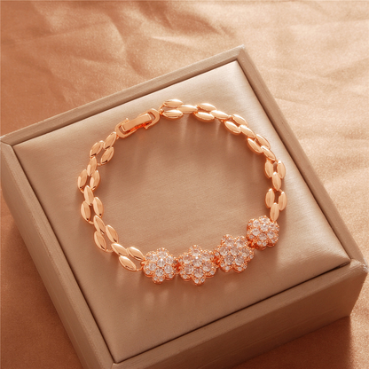 Gold Tone bracelet, style TSL035, with three flower centers and polished leaf-shaped links and a clasp.