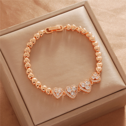 Gold Tone bracelet, style TSL036, with stone-set heart centers and polished heart-shaped links and a clasp.